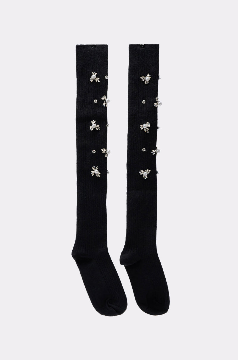 The COCO EMBELLISHED SOCKS are black over-the-knee socks adorned with clusters of shiny beads in floral patterns along the front. 3