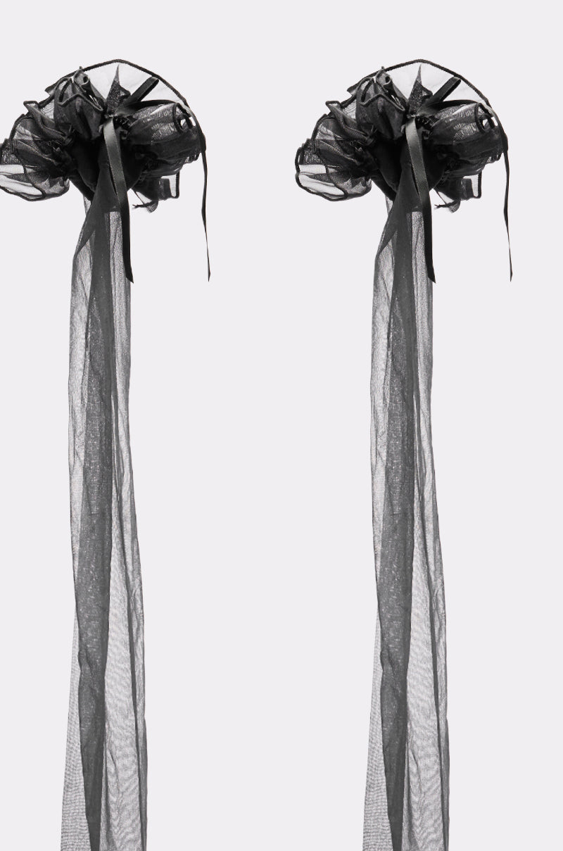 Two BECKY BOW STOCKINGS, each black and sheer with flowing ribbon details, are displayed side by side on a plain white background, evoking the elegance of delicate headpieces inspired by classic sheer stockings. 2