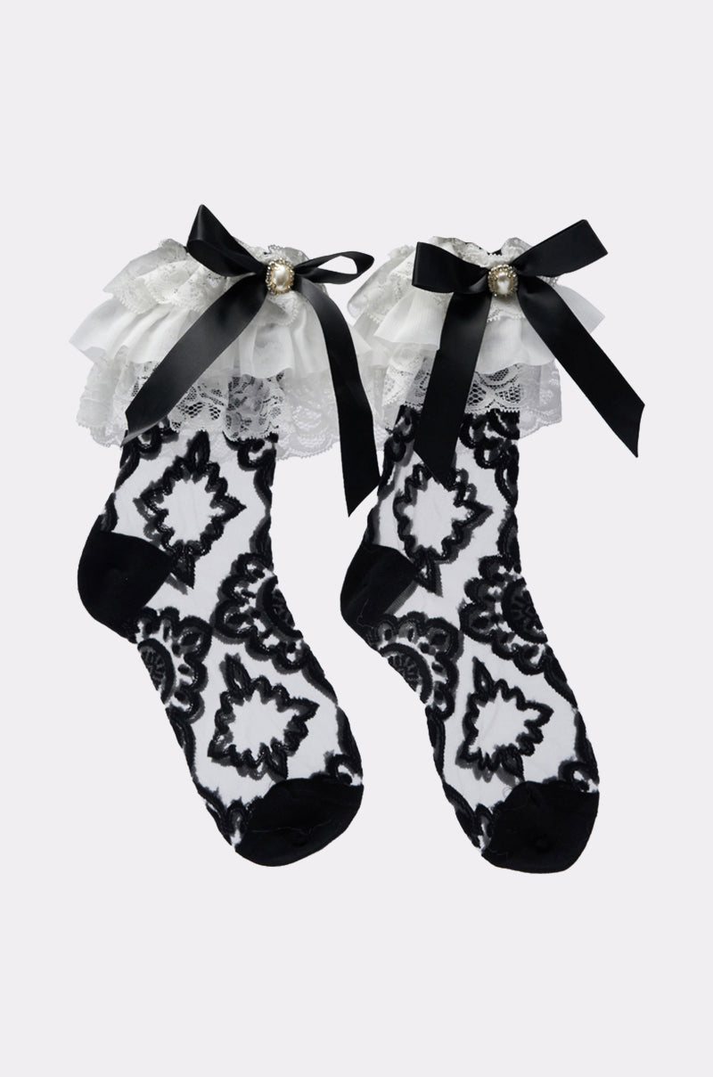 GALA BOW SOCKS feature black and white floral patterns, frilly lace cuffs, large satin bows, and pearl accents—perfect for adding elegant style to any outfit. 1