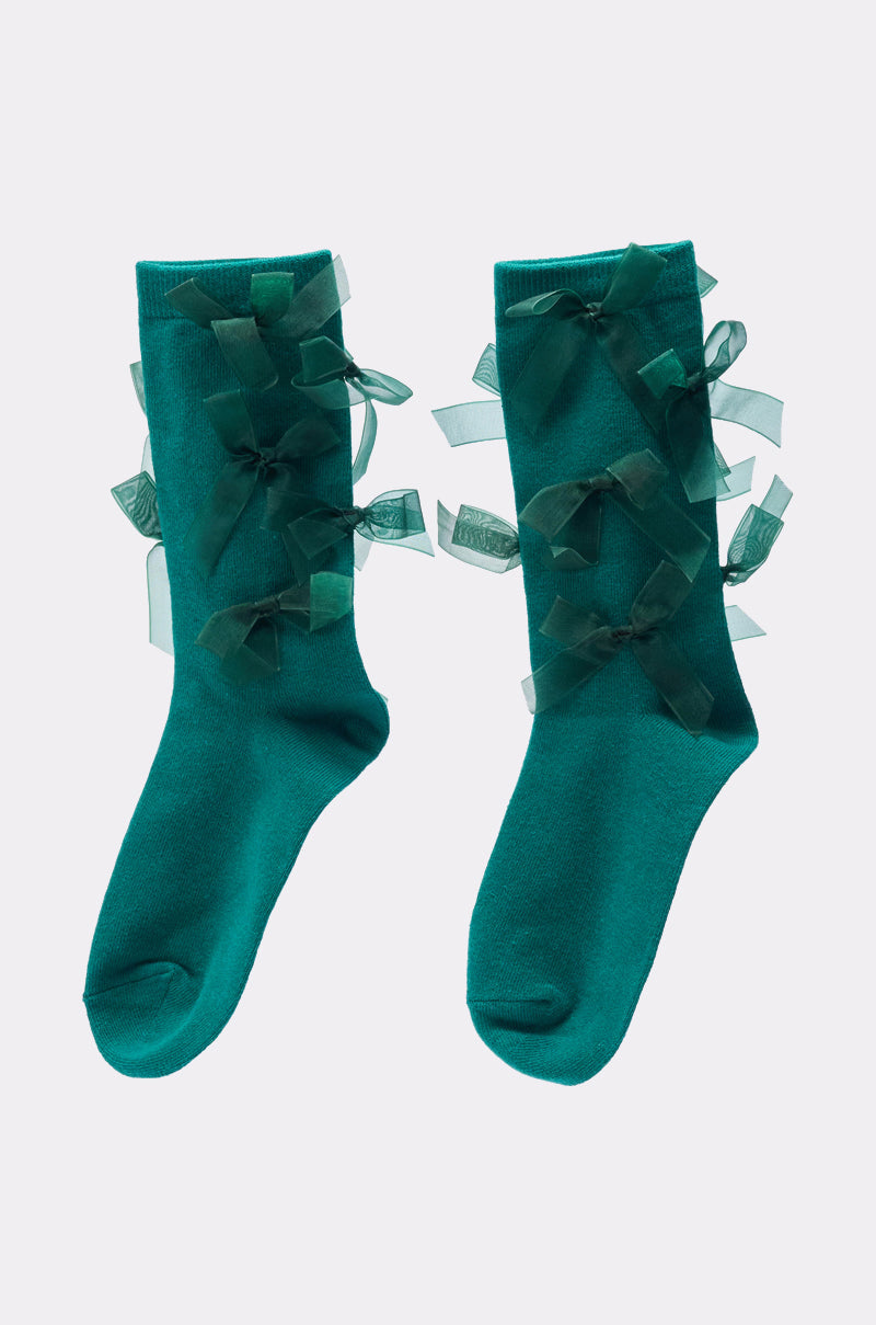 The EMMY BOW SOCKS are teal coquette socks featuring sheer matching teal organza ribbon bows along the sides, shown flat on a light background. 2