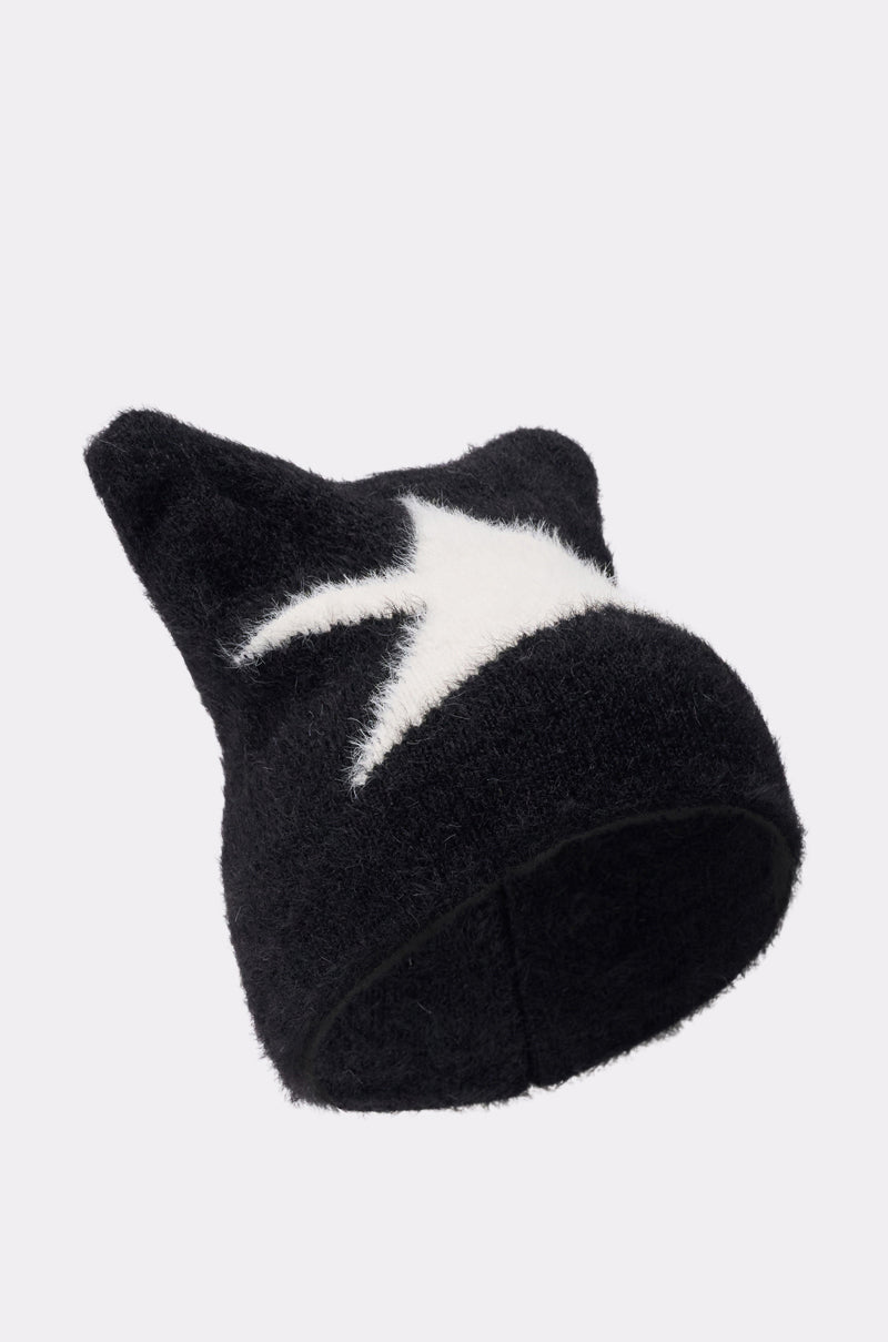 The IT GURL BEANIE is a black knit hat featuring pointed cat ear corners and a white lightning bolt design on the front, shown against a plain light gray background. 1