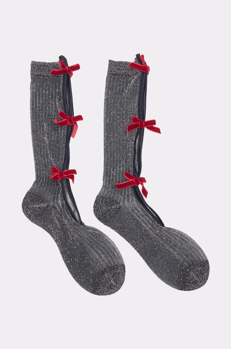 TIS THE SEASON BOW SOCKS: Festive gray, knee-high socks with a ribbed texture and three red velvet bows on each side along a black ribbon—playful, sparkling bow socks for holiday cheer. 1