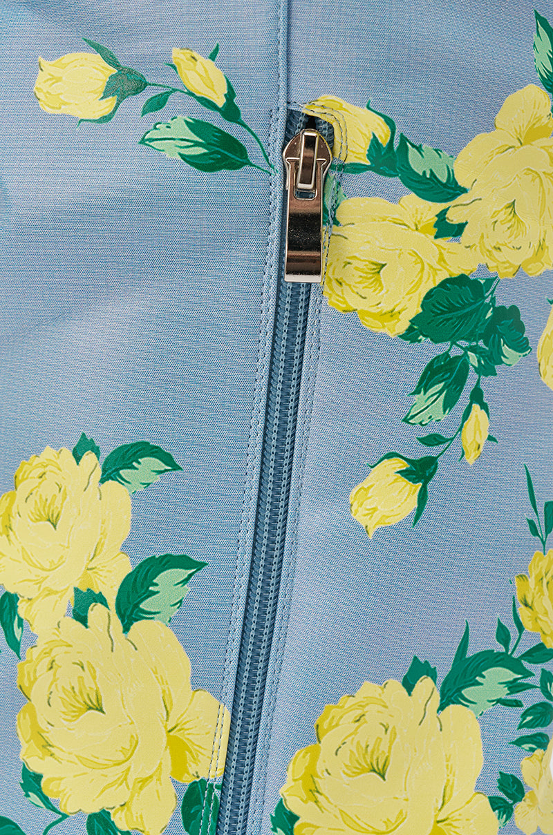 A close-up of the AKIRA GOLD GARLAND BLUE FLORAL BOOT shows blue fabric with yellow roses, green leaves, and a vertical zipper—a stylish floral footwear detail. 8