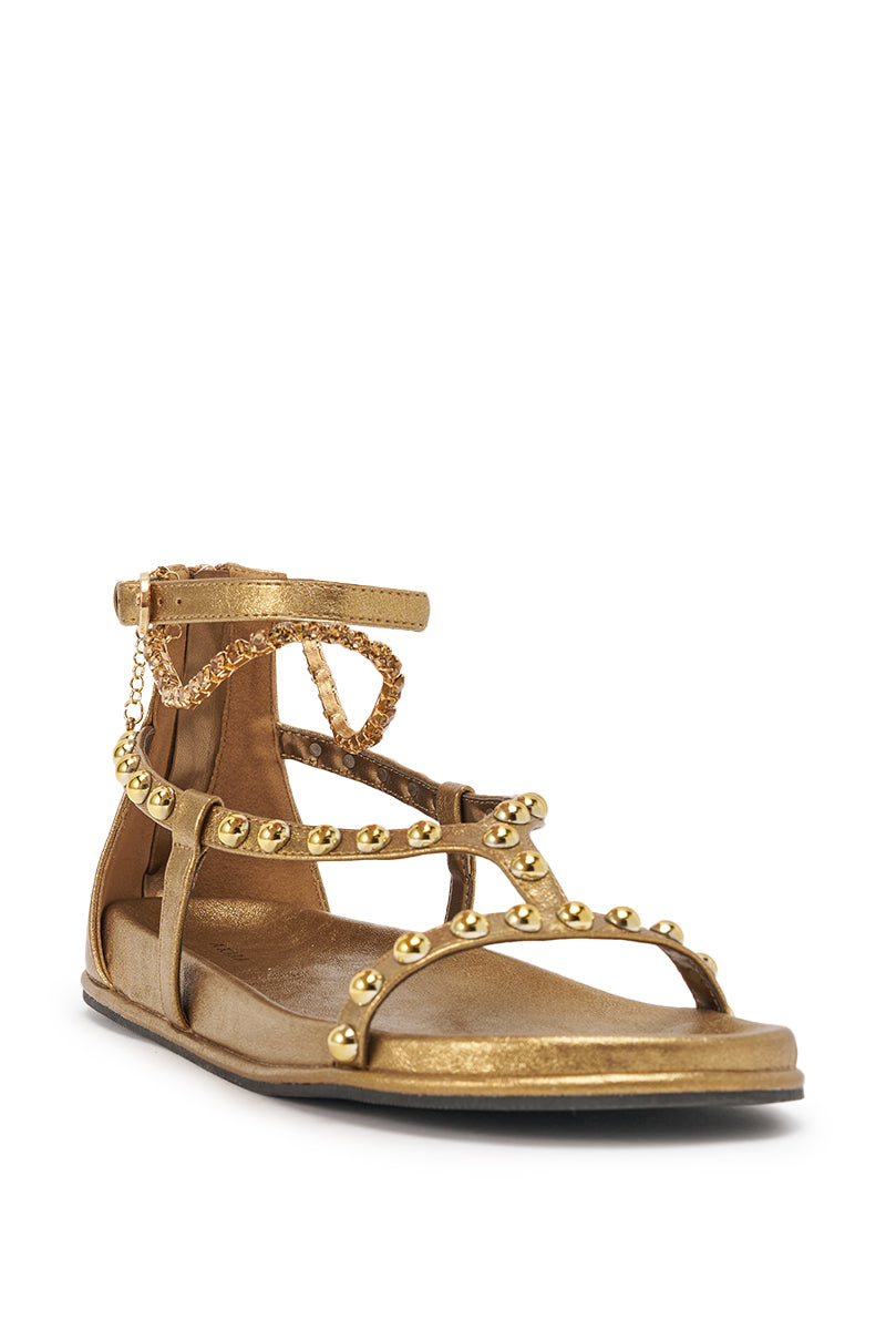 The AKIRA GATO BRONZE GOLD METAL EMBELLISHED FLAT SANDAL features gold studs, ankle chains, an open toe, faux leather with a metallic finish, and a back zipper for easy wear. 4