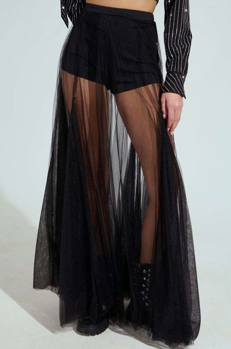 Person wearing black shorts and the MY ALL MAXI TULLE SKIRT with black lace-up boots and a black and white striped long-sleeve top.
