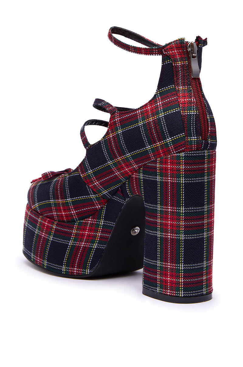 The AZALEA WANG GEORGINA MULTI PLAID CHUNKY PUMP is a high-heeled platform featuring bold red, green, and yellow tartan plaid with buckle straps and a back zipper.