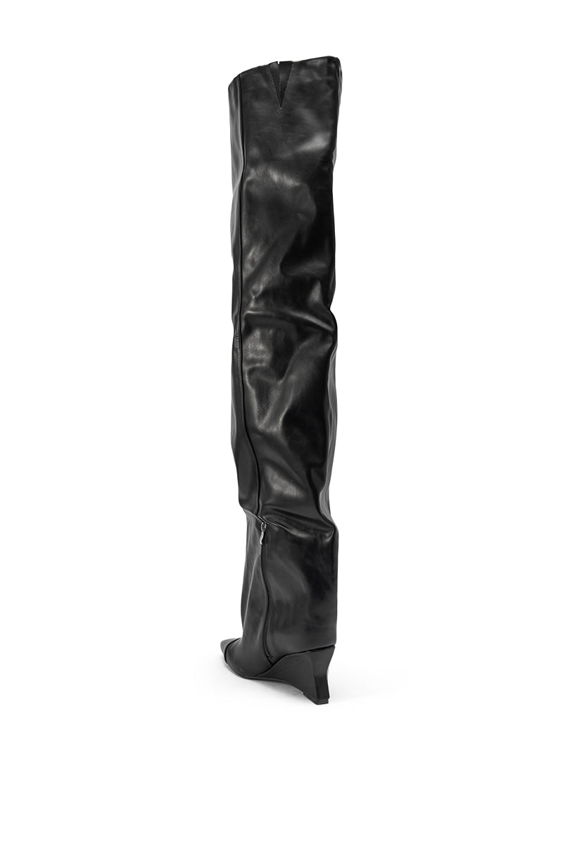The AZALEA WANG GHANA OVER THE KNEE BLACK PU WEDGE BOOT is a single black, slouchy, thigh-high boot with a pointed toe, low wedge heel, and faux leather finish, displayed against a white background. 4