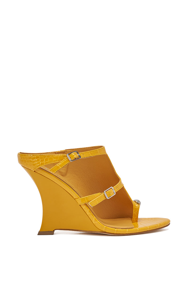 The AKIRA GOLD GINO MUSTARD CROC WEDGE SANDAL features croc-embossed faux leather, a textured finish, open toe with toe loop, two thin adjustable straps with silver buckles, and a high curved wedge heel. Shown on a white background. 3