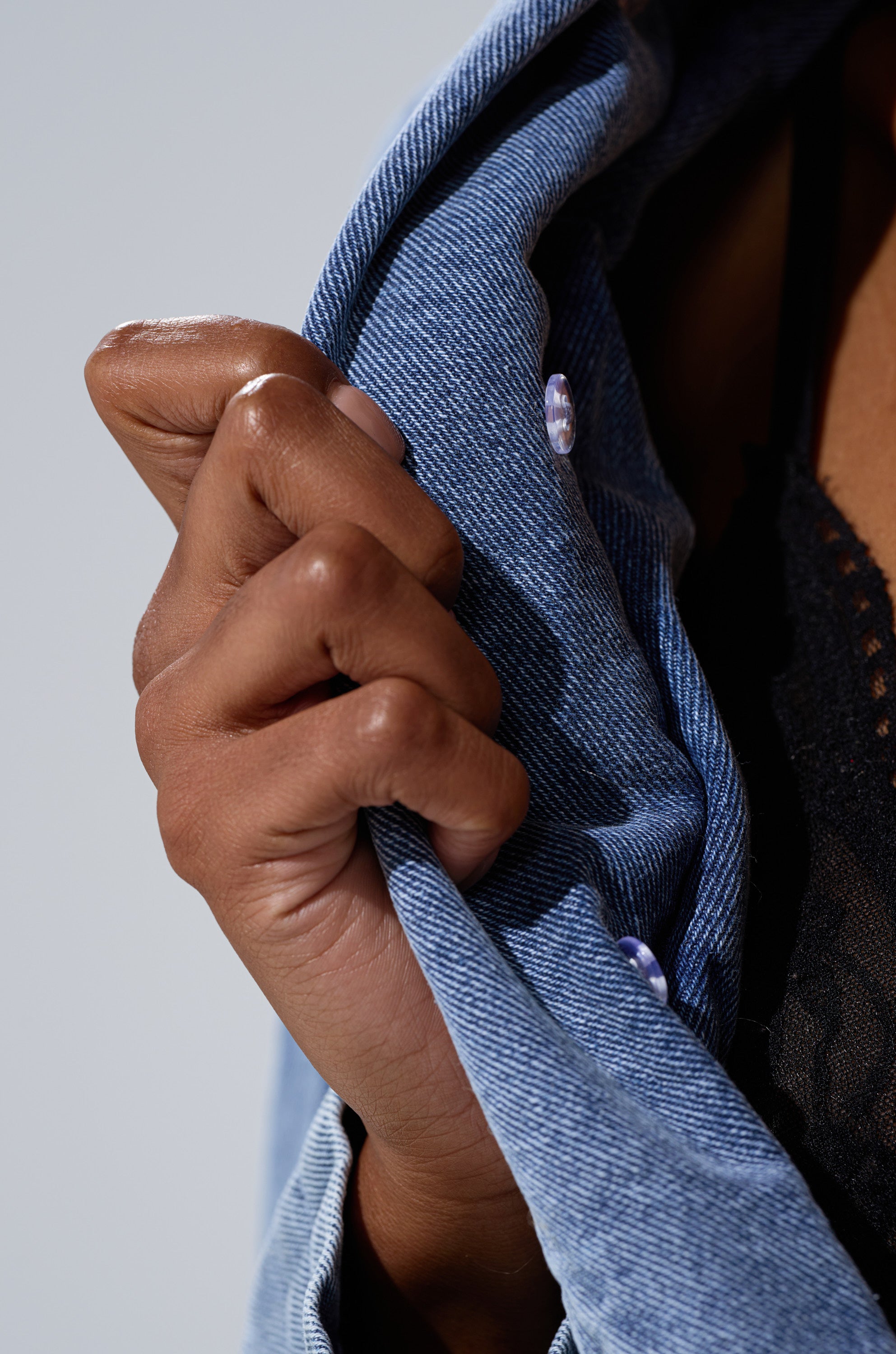 A close-up shows a hand gripping the collar of the NEW GISELE CROPPED FUR TRIM JACKET, with a black lace top visible beneath. The blurred, light background enhances the Bratz Doll-inspired aesthetic.
