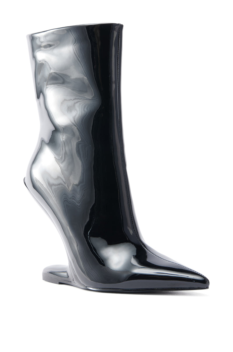 The AZALEA WANG GLACIELLE PATENT BLACK WEDGE BOOTIE showcases a glossy, black pointed toe crafted from faux patent leather with an angular design and inverted wedge heel, styled elegantly on a plain white backdrop.