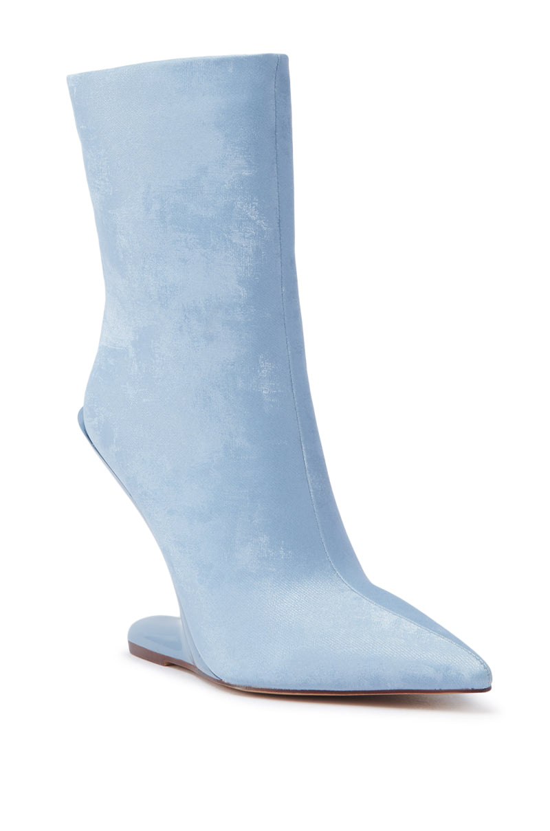 The AZALEA WANG GLACIELLE BLUE WEDGE BOOTIE boasts a velvet-like finish, pointed toe, and sculptural wedge heel, set against a crisp white background.