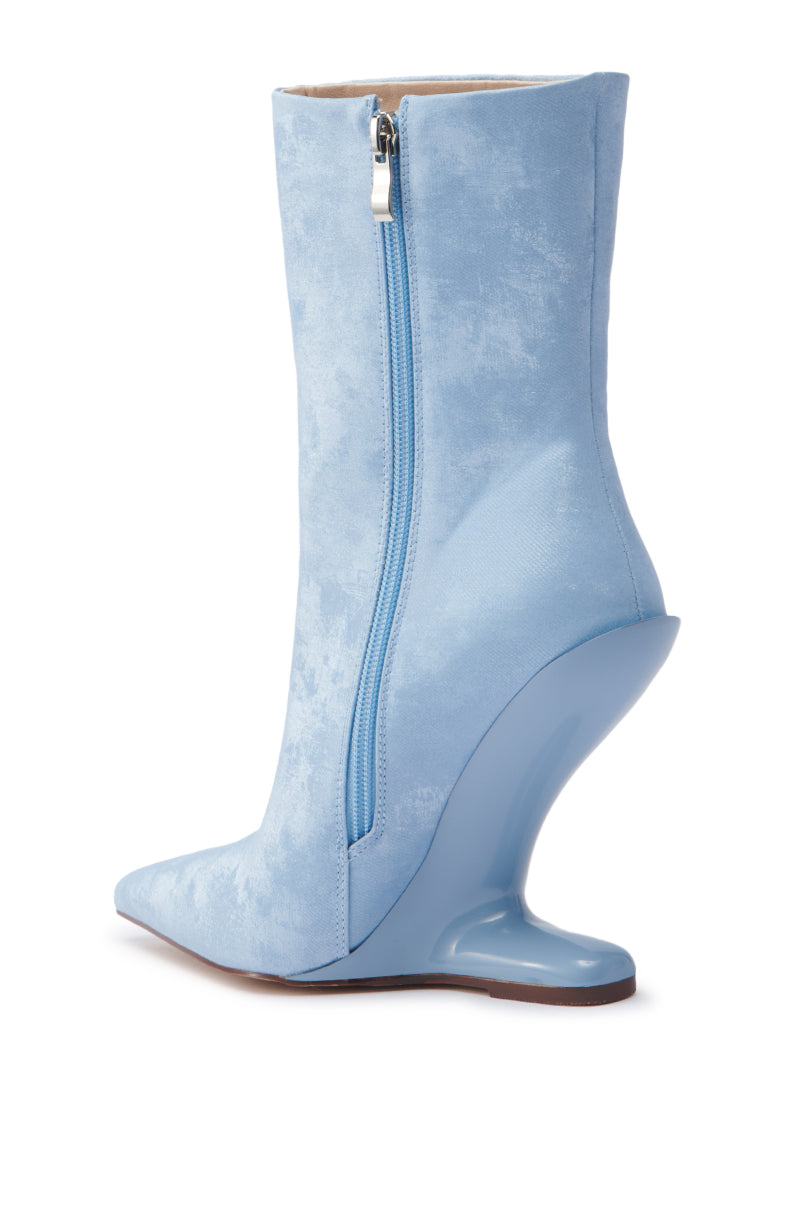 The AZALEA WANG GLACIELLE BLUE WEDGE BOOTIE features a velvet-like finish, pointed toe, side zipper, and a sculptural wedge heel for a modern edge in this light blue high-heeled boot.