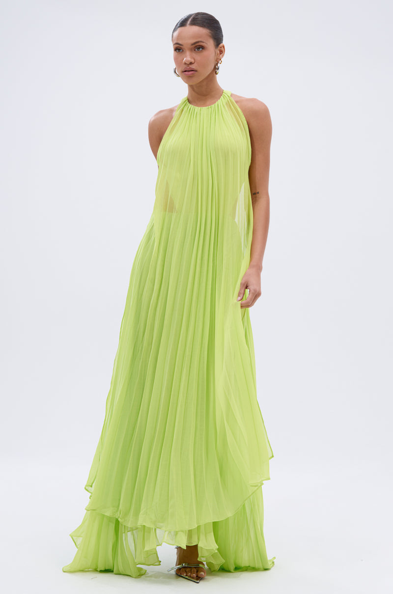 A woman stands against a white background wearing the NIXEN MAXI DRESS WITH CHIFFON OVERLAY—a flowing, sleeveless lime green maxi dress with sheer, pleated fabric.