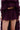 A person wearing ROYAL BLOOMER SHORTS made from layered, deep purple sheer chiffon with a high-rise fit. The photo is cropped to display the lower torso and upper legs.