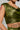 A person dressed in the shimmering green METALLIC DREAM BLOUSE, sleeveless to reveal tattoos on their arm and torso. The fabric features a textured, iridescent look that accentuates its cropped silhouette, while the person's head is partially out of frame.