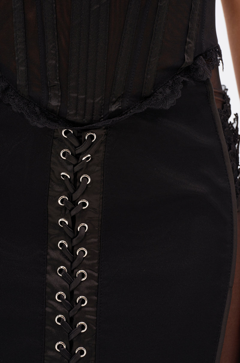 Close-up of the LET ME REMIND YOU LACE UP MESH MIDI DRESS, showcasing a corset-inspired bodice with vertical boning, lace accents at the waist, crisscross laces through metal eyelets, and a curve-hugging skirt for a bold silhouette.