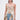 A woman wears the ROYAL ENERGY BROCADE CORSET TOP, featuring a vintage-inspired floral print, paired with high-waisted blue jeans with floral fabric panels and large bows. She has long straight hair and statement earrings against a plain white background.