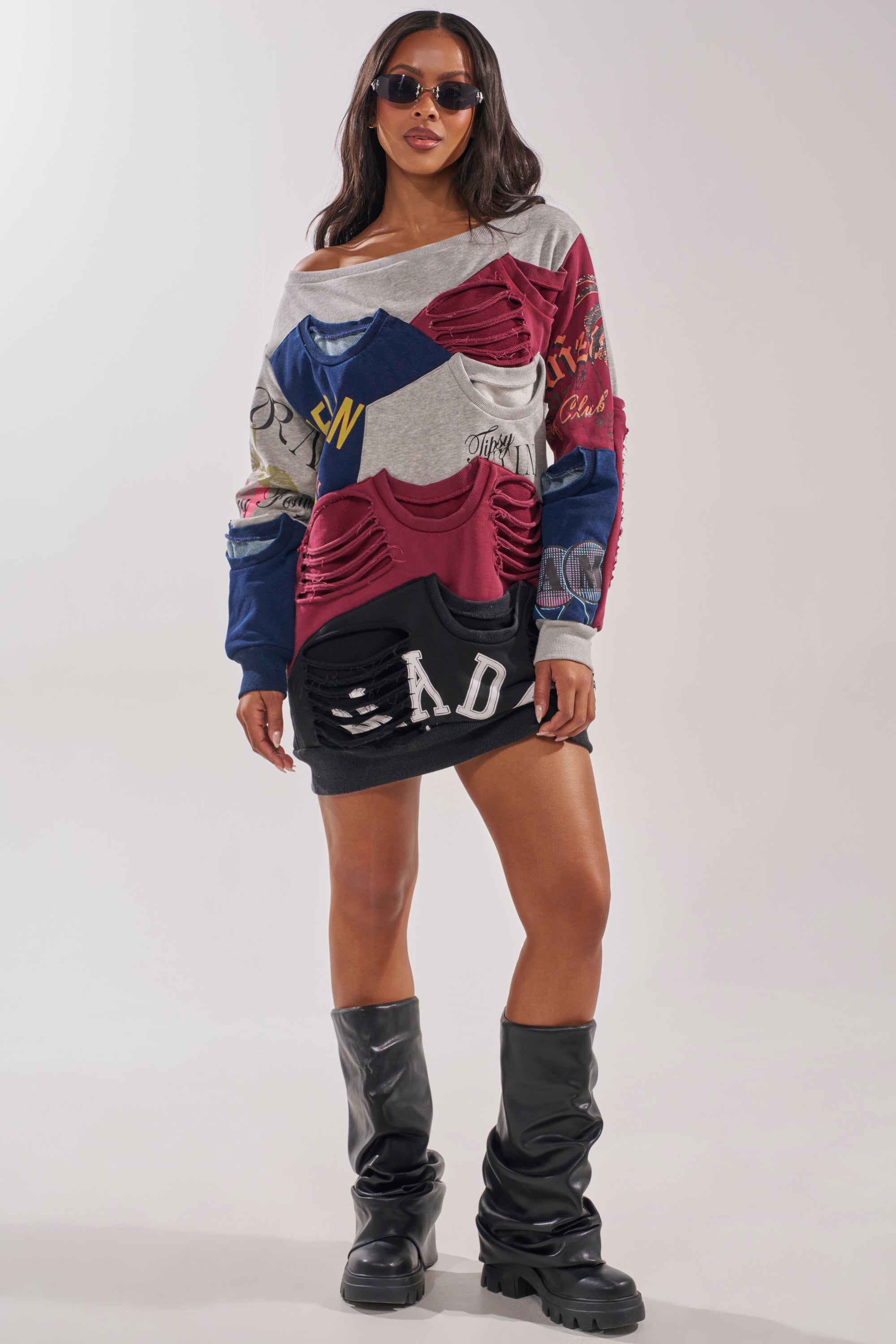 A woman in the TALK LATER OFF THE SHOULDER PATCHWORK DRESS, sunglasses, and knee-high black boots models bold street style against a plain background. 5