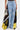 Only the lower torso and legs are visible, dressed in DONT MESS WITH ME WIDE LEG DENIM PANT—high-rise, wide leg light blue denim with ripped details and black/yellow fabric panels—paired with a small silver handbag.