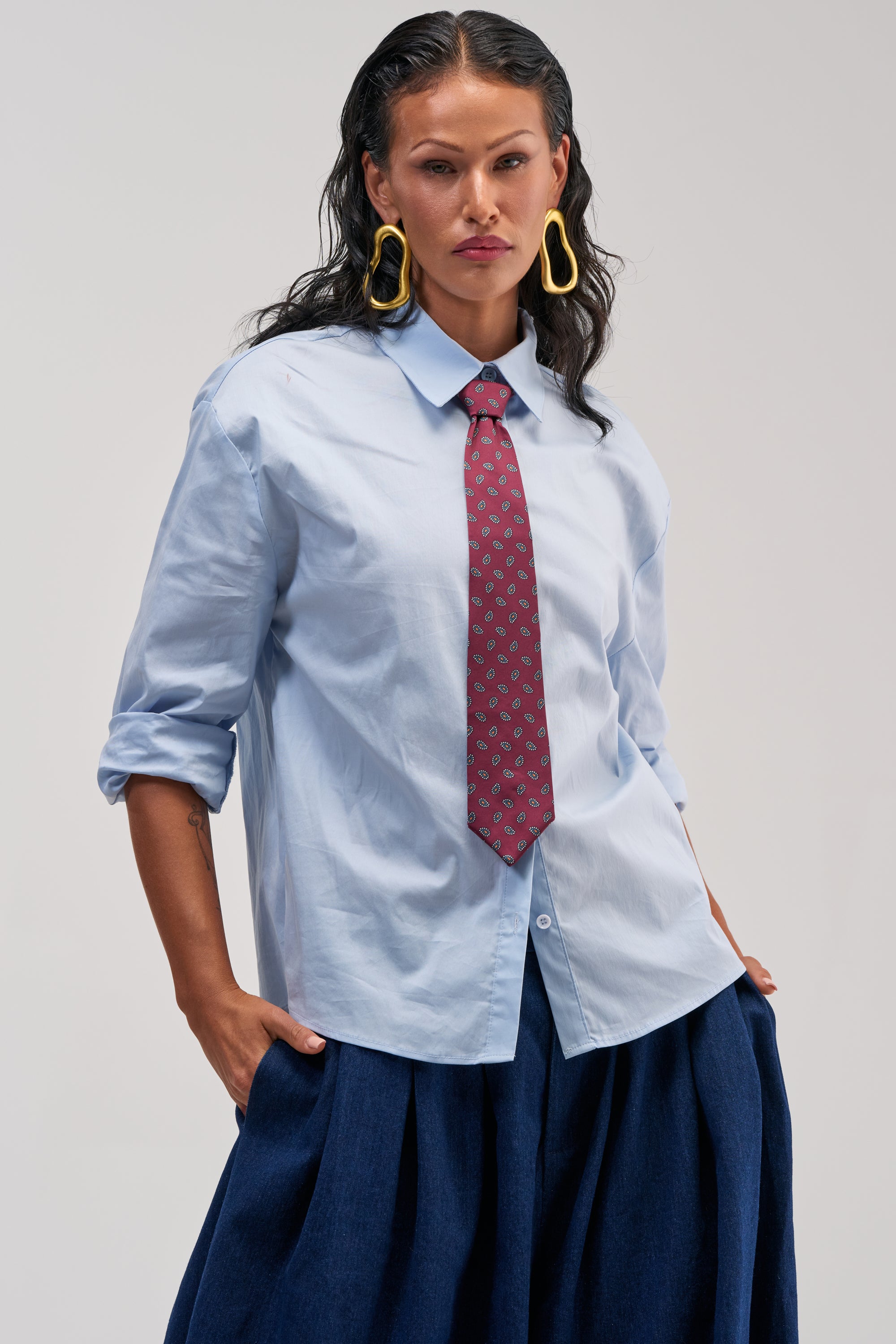 Relaxed denim styled with oversized button-down shirt and silver sneakers
