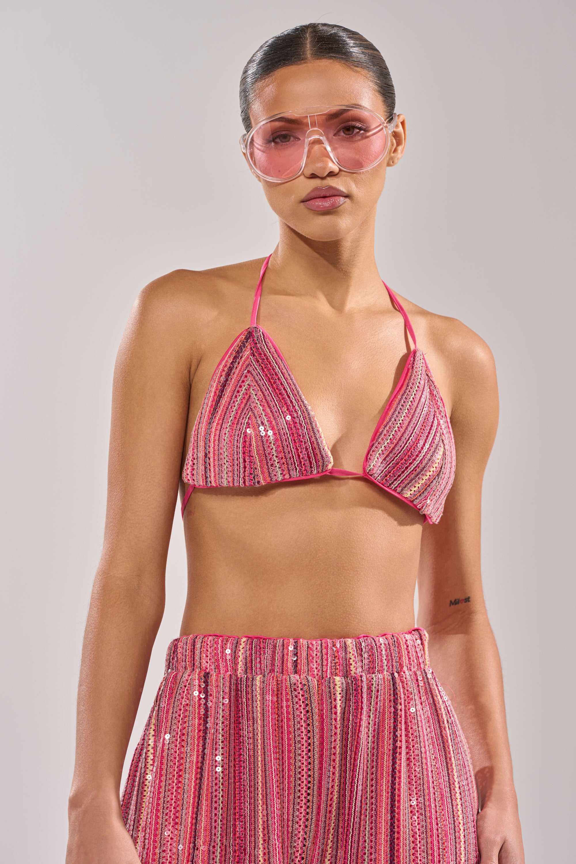 A woman in the TAYLOR SEQUIN BRALETTE and matching high-waisted pants, with pink-tinted sunglasses and slicked-back hair, poses against a plain light background. 5