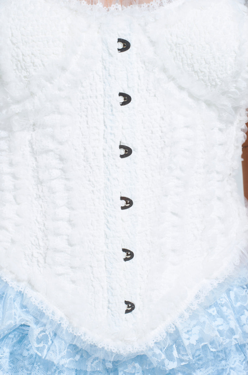 Close-up of a textured FEELS RIGHT FLUFFY TRIM CORSET TOP with black hook-and-eye closures and satin lining, paired with a light blue lace skirt. The intricate fabric and lace design create an elegant vintage look, enhanced by its strapless style.