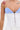 A person models the KLYA CORSET, showcasing blue and white striped colorblock panels with decorative buttons. Tattoos are visible on their shoulder and chest, and the image is cropped to display only the upper torso.