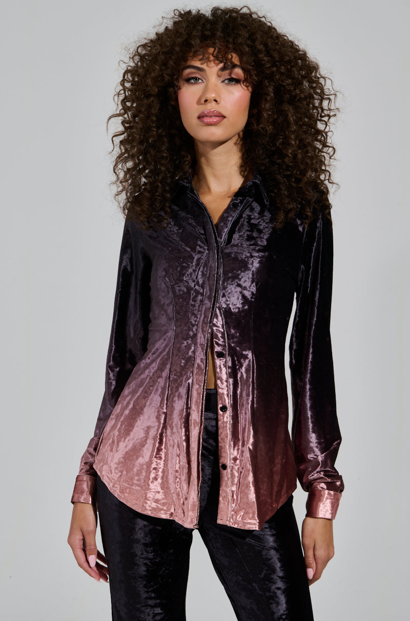 A person with curly hair wearing the chic "Never Switch Up Ombre Button Down Blouse in Black," paired with matching pants, stands against a plain background—creating a perfect holiday ensemble.