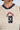 Close-up of a person wearing the ADDICTED RUCHED JERSEY TOP in cream with navy collar, featuring sporty red "CAVIA R GAL" text and a navy "68" on the front.