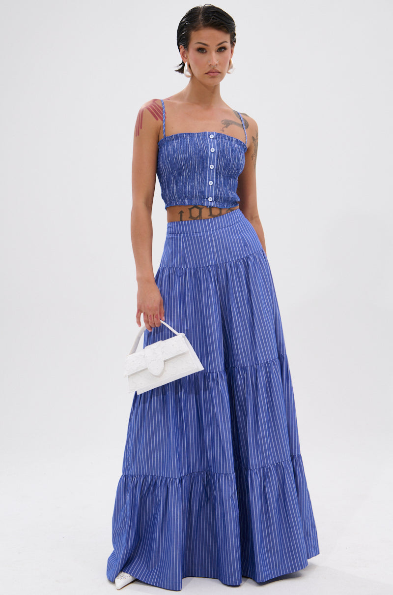Wearing the BUSINESS ONLY STRIPE PALAZZO PANT and a blue and white striped sleeveless crop top, a person with short dark hair holds a small white handbag while standing against a plain white background.
