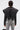 A person with short dark hair wears the COSMO ZIPPER MOTO—a faux leather jacket with dramatic pleats and exposed zippers—paired with light grey distressed jeans and carries a small chain-strap purse.
