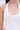 A close-up of a woman wearing the DESTINY CORSET, a white halter top with halter-style straps and a scoop neckline. The photo is cropped from nose to waist, highlighting the flattering fit and detailed fabric.