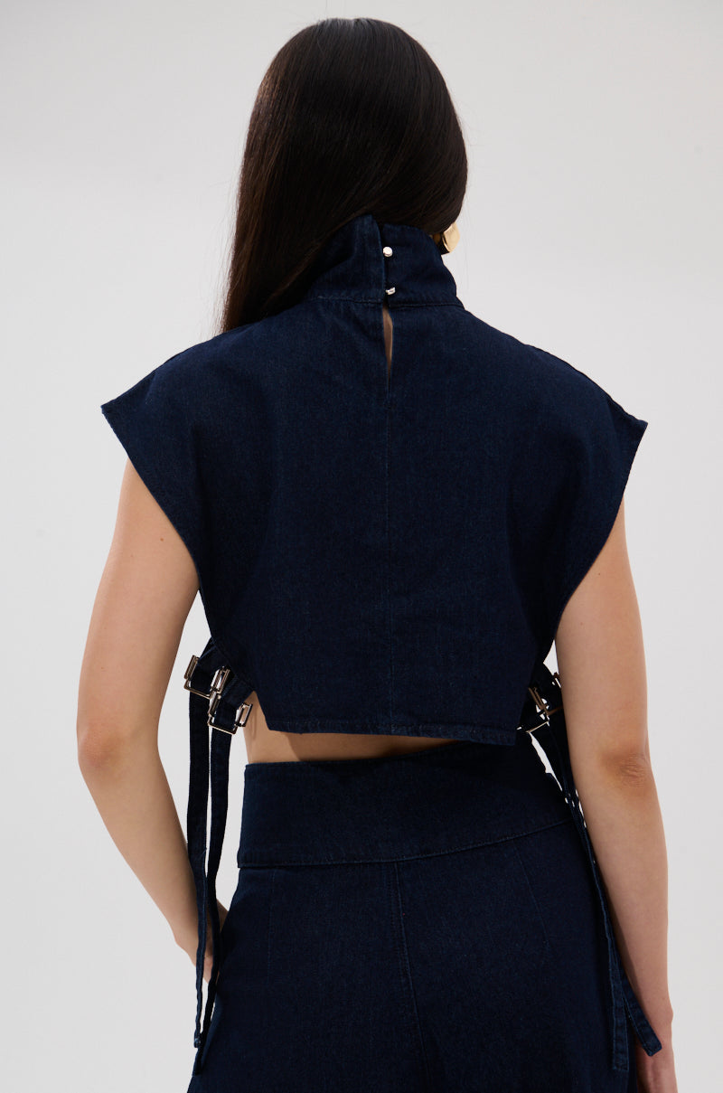 A person with long dark hair is seen from the back, wearing the YOU A REAL ONE DENIM BLOUSE featuring a tailored fit, high collar, and metallic fasteners, paired with matching high-waisted denim pants.