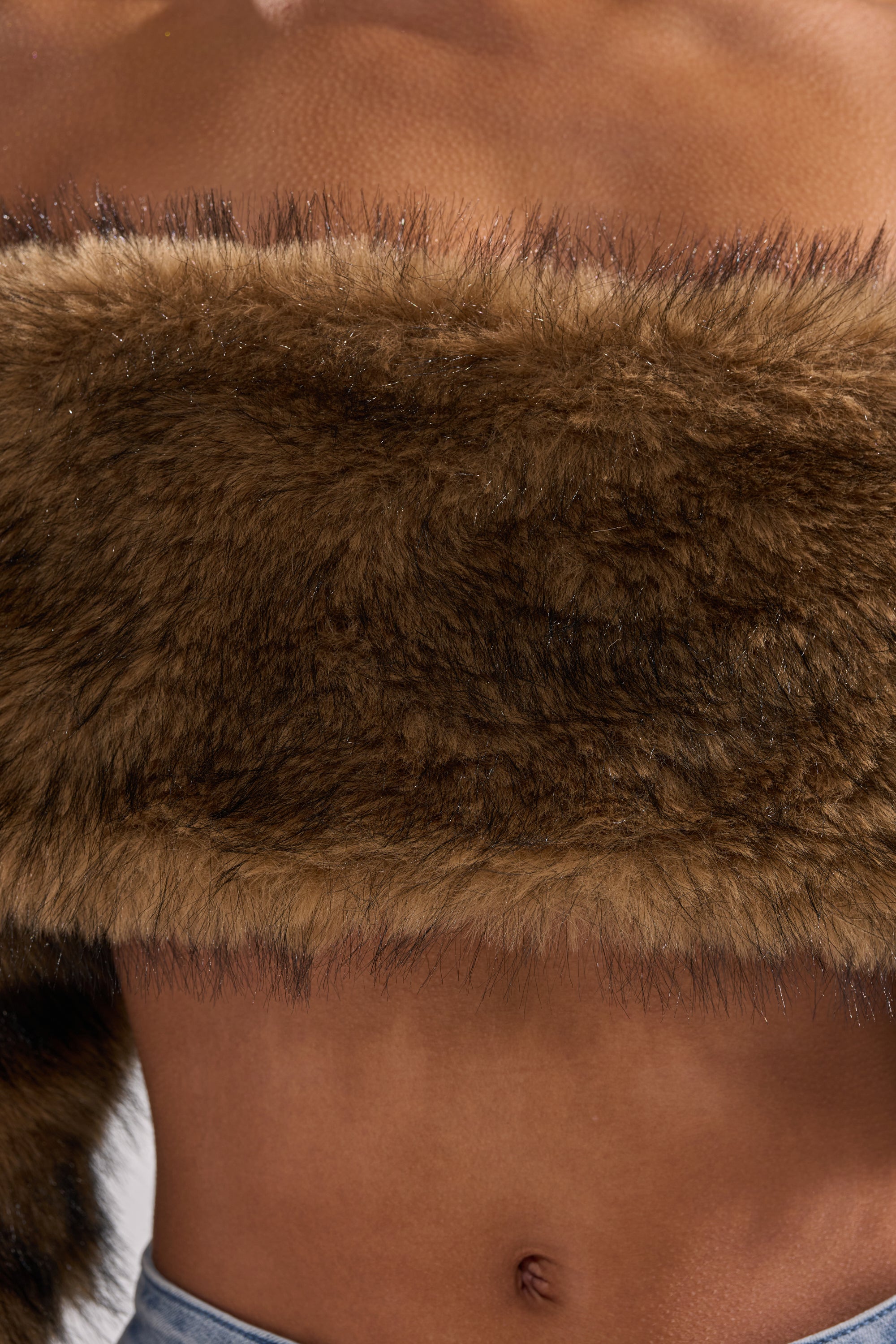 A close-up shows someone wearing the TEDDY BEAR CROPPED LONG SLEEVE TOP, exposing their midriff and belly button, paired with blue denim jeans for a cozy, winter-ready look.