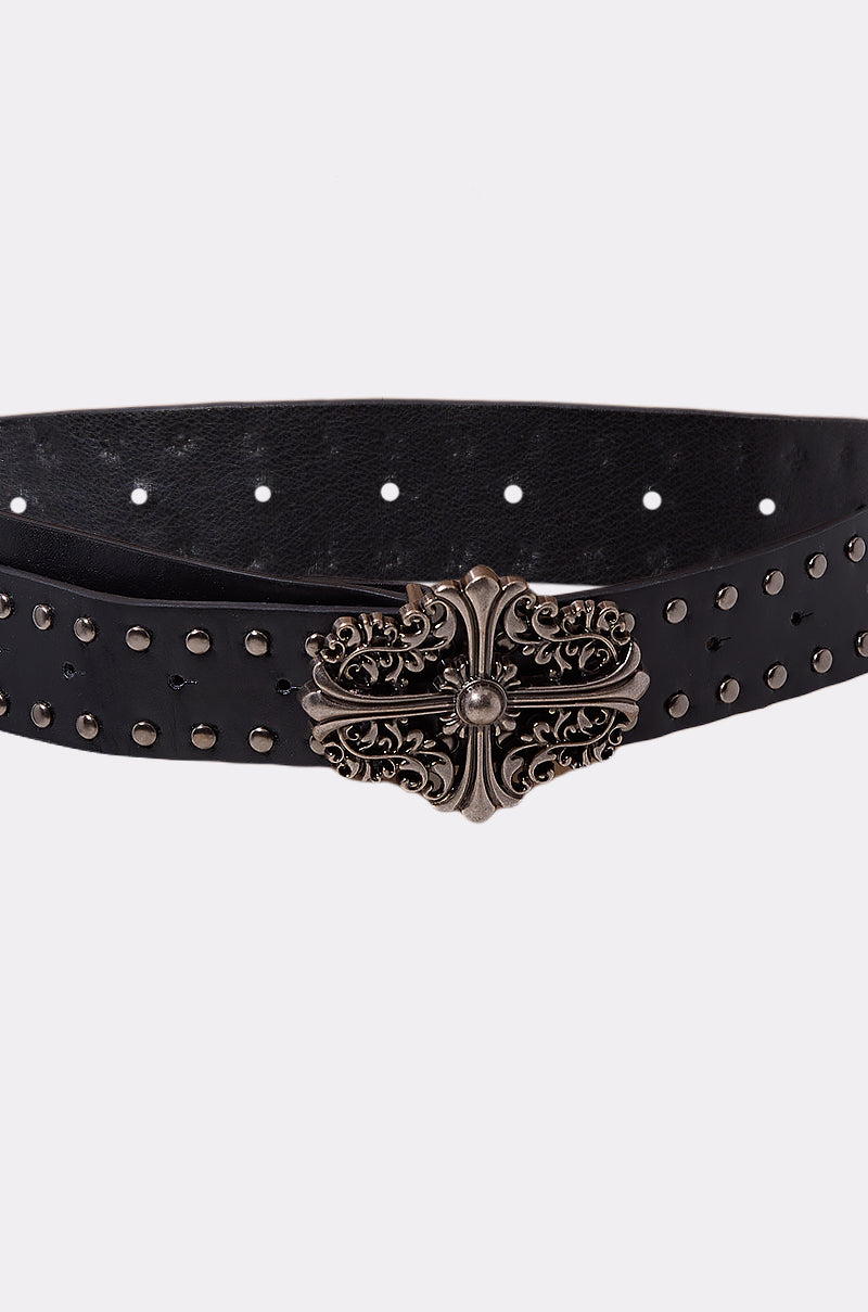 The CROSS ME BELT is a black punk rock belt featuring small metallic studs along its length and an ornate, vintage-style silver buckle with intricate detailing.