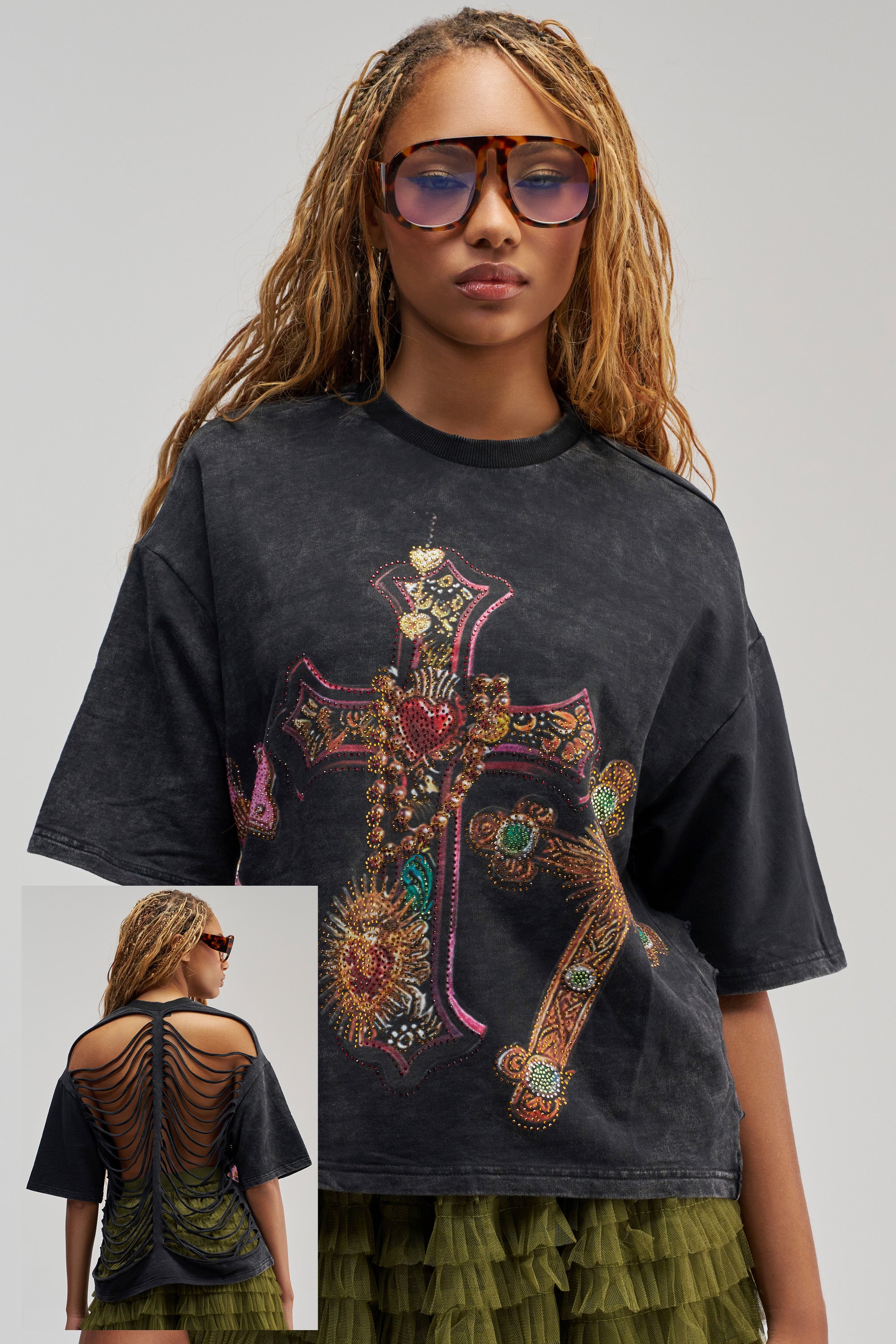 Sporting long, blonde braids and a green ruffled skirt, the woman showcases the CROSS MY HEART RHINESTONE DISTRESSED TEE—a black top adorned with a colorful beaded cross design for an effortless streetwear look. The inset highlights the back’s distinctive cut-out woven details and eye-catching yellow accents. She completes her bold style with sunglasses.