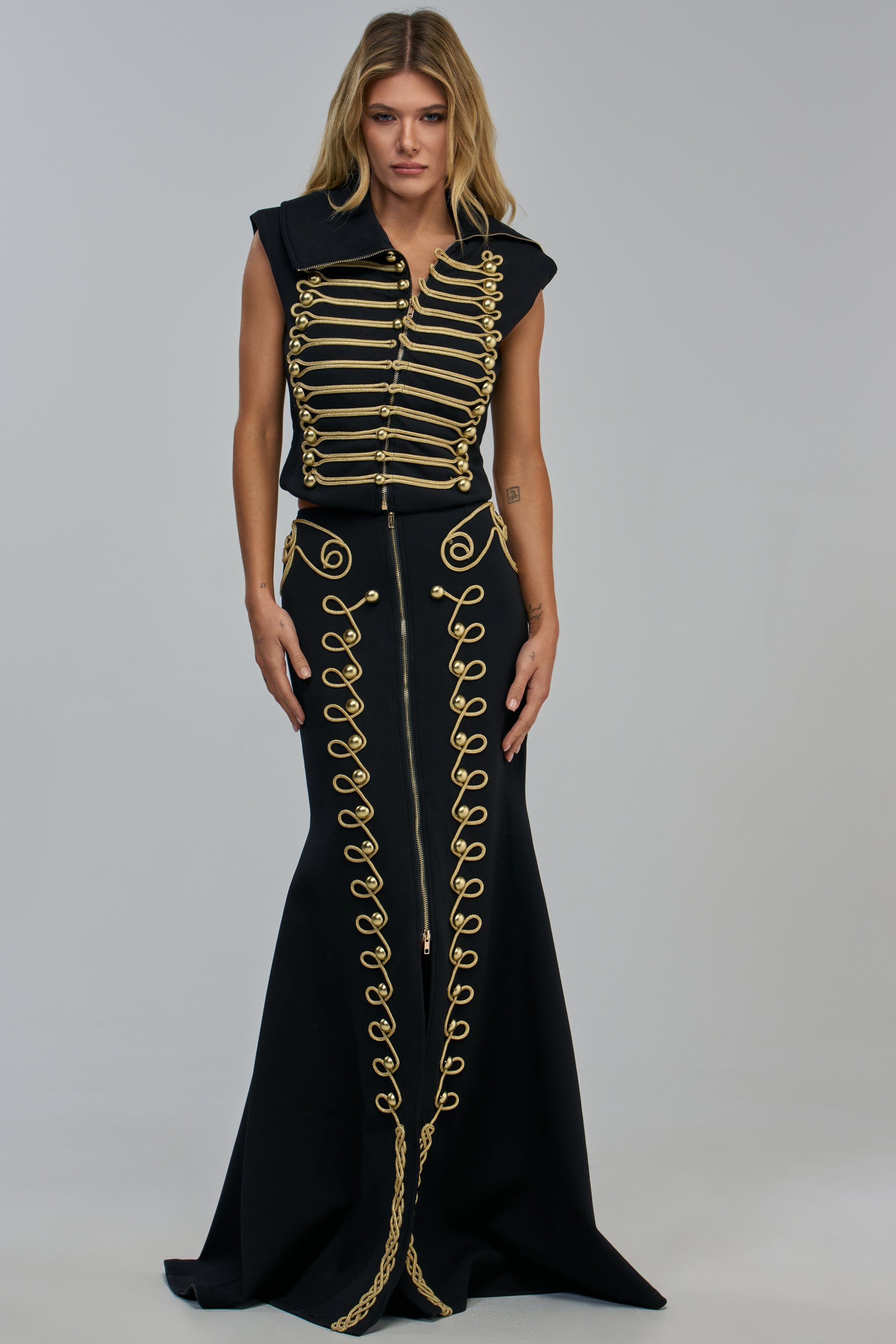 RARE BREED SCUBA MAXI SKIRT paired with a matching sleeveless jacket featuring gold military-style braided trim and brass buttons.