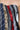 Close-up of the STRICTLY BUSINESS TIE DETAIL CORSET TOP, a strapless dress featuring an eclectic mix of neckties with patterns like stripes, floral, and paisley in blue, black, red, and beige tones. The asymmetrical design highlights the texture variety of the ties.