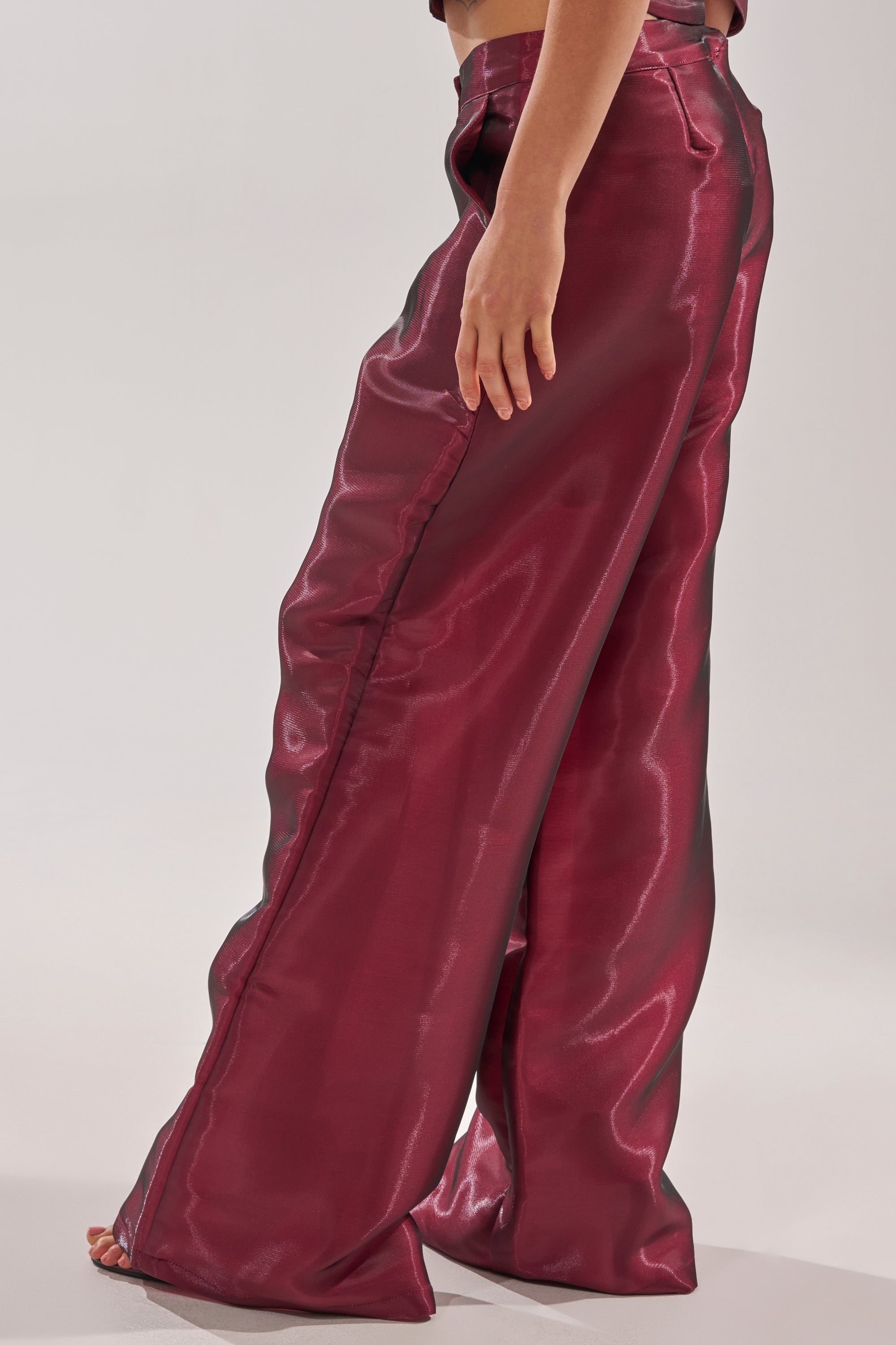 Someone wearing the ON FIRE TROUSER, a high-rise wide-leg pant in a bold red shade. 3