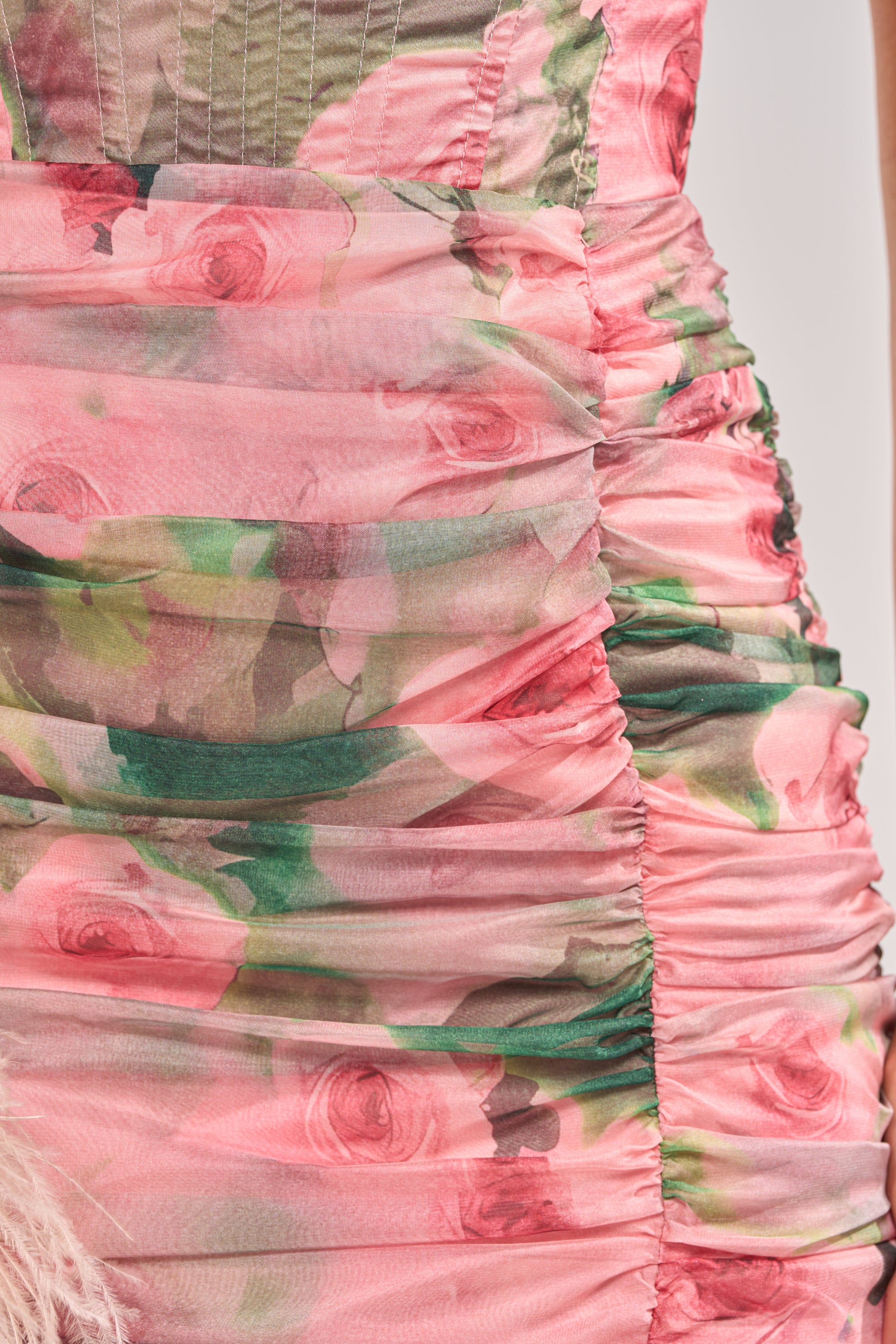Close-up of the DREAMING FLORAL MAXI SKIRT, featuring ruched, sheer fabric with pink, green, and beige pastel rose prints. The gathered layers create textured folds reminiscent of a flowing chiffon silhouette. 6