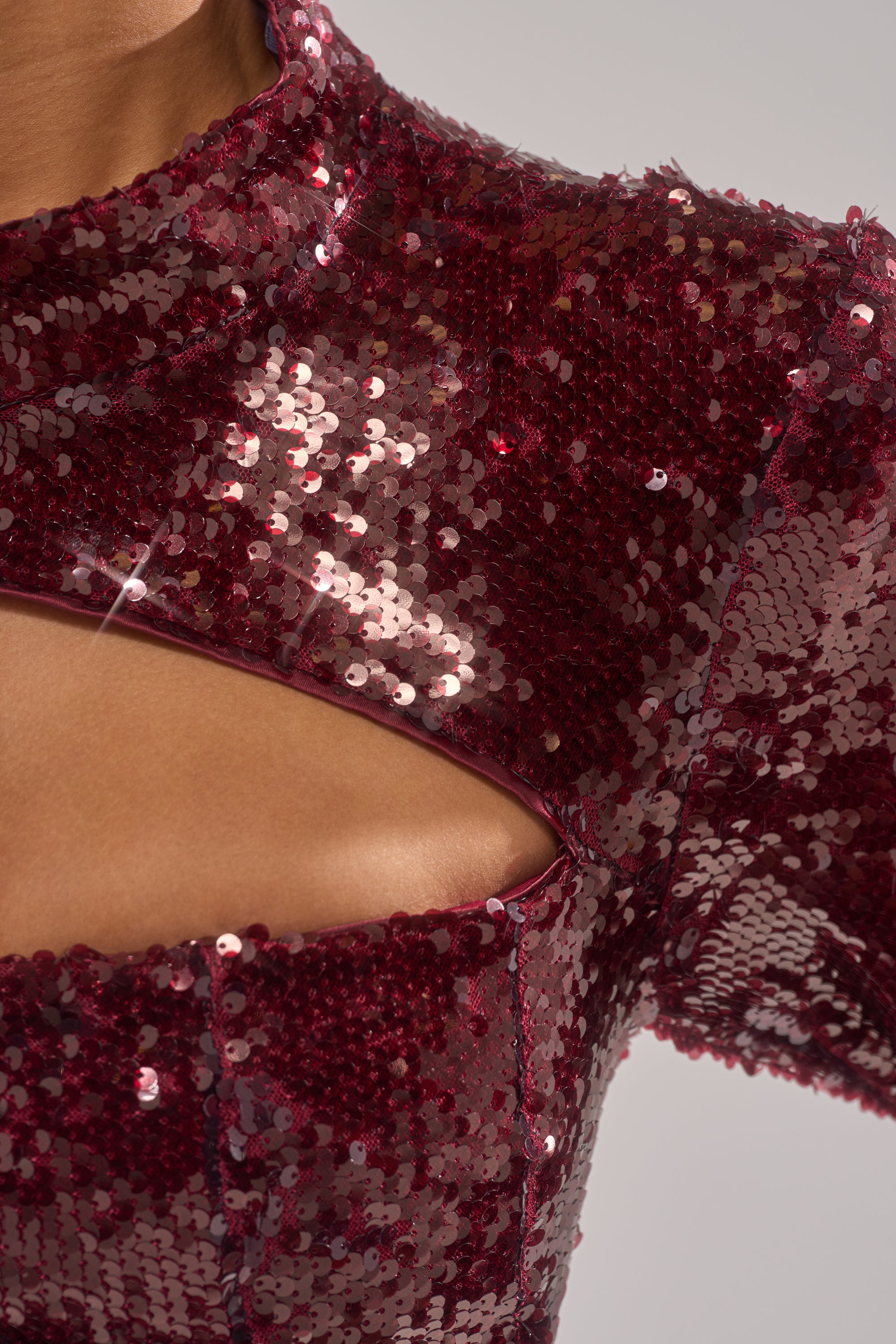 Close-up of a person wearing the IM YOUR FAVORITE SEQUIN MINI DRESS in red, featuring a sparkling sequin finish and a cutout near the neckline that reveals part of the chest and shoulder for a festive look.