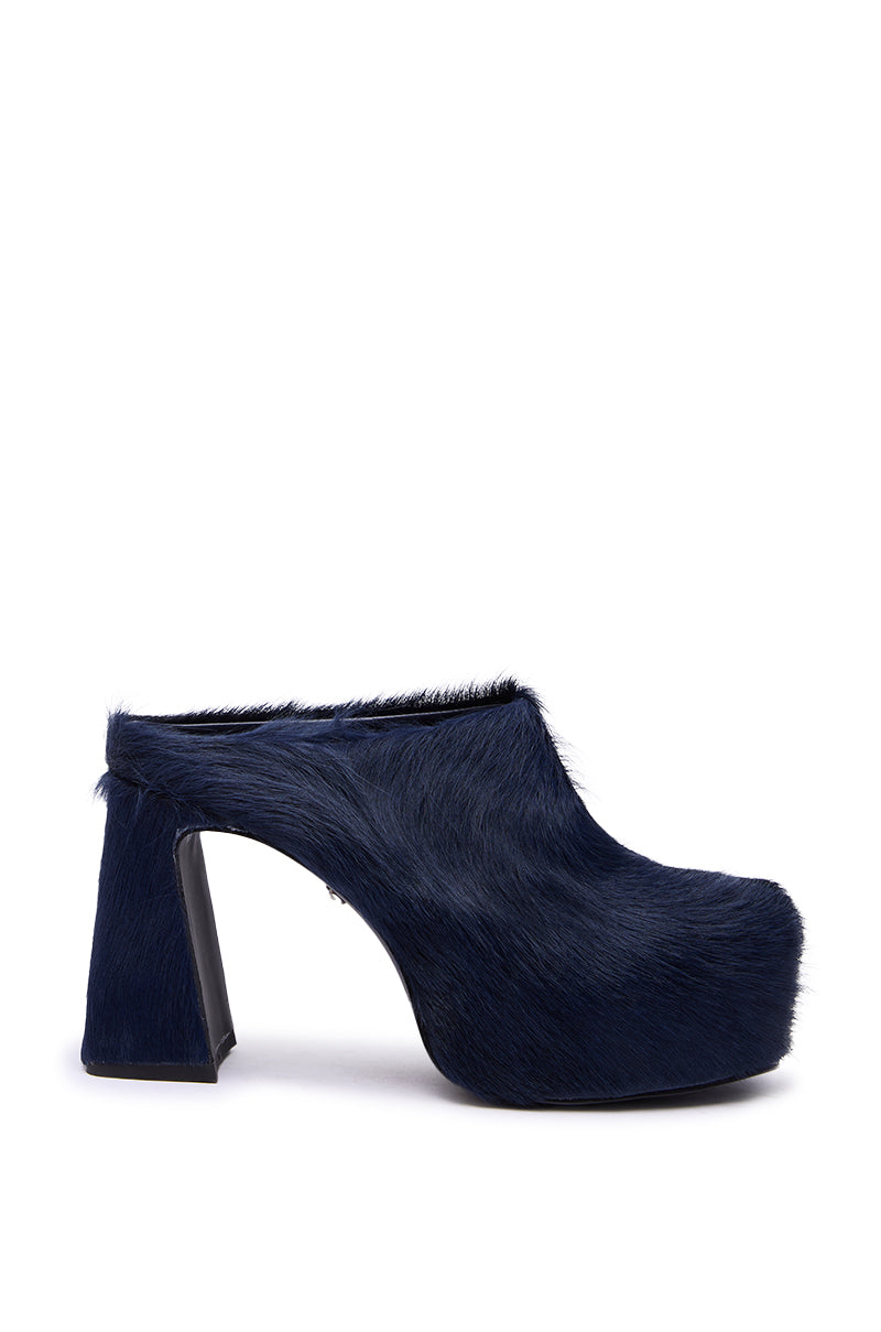 The AZALEA WANG GOLDING NAVY PONY HAIR CHUNKY PUMP is a navy blue mule with faux fur, a chunky block heel, closed rounded toe, and platform sole, shown in side view against a white background. 4