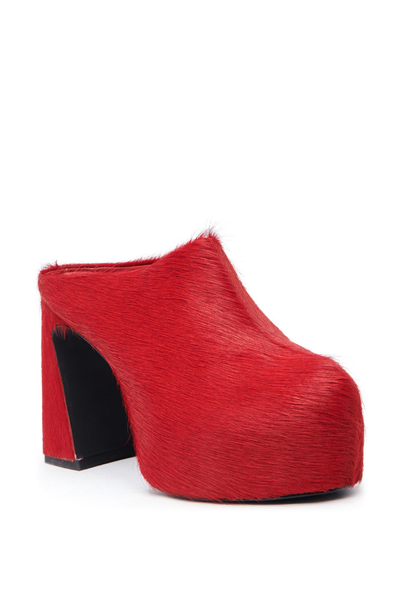 The AZALEA WANG GOLDING RED PONY HAIR CLOG PUMP features a chunky, high heel, closed toe, open back, and bold platform sole, all covered in striking red pony hair.