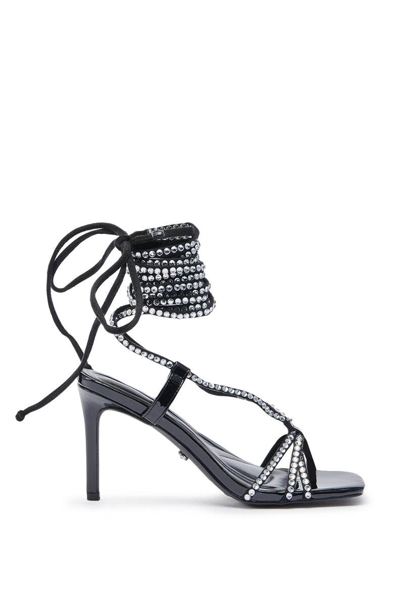 The AZALEA WANG GOMER SPARKLE RHINESTONE LACE UP SANDAL is a black faux patent leather stiletto with a pointed toe, ankle wrap strap, and multiple rows of shining rhinestones for added glamour. 3