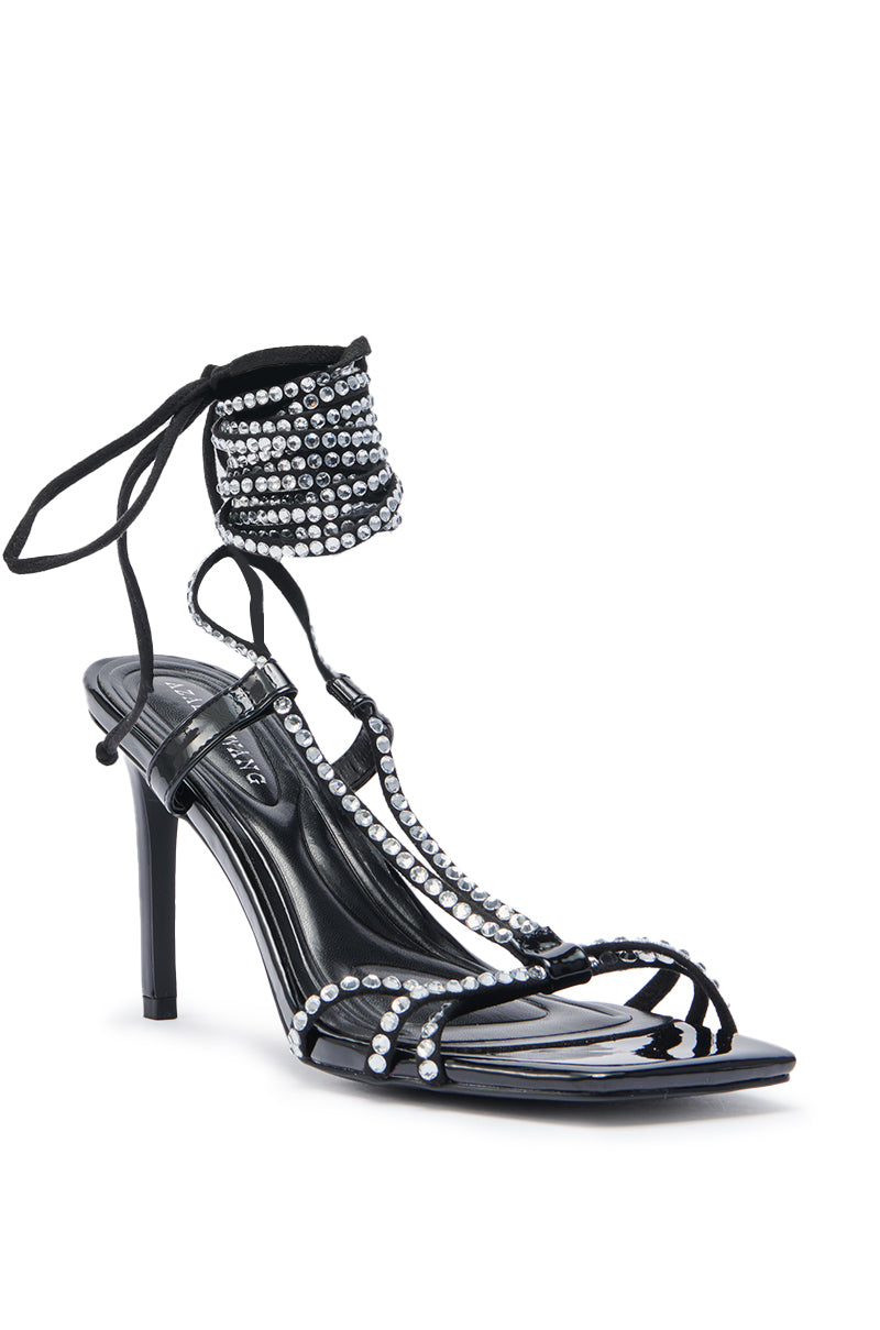 The AZALEA WANG GOMER SPARKLE RHINESTONE LACE UP SANDAL is a black faux patent high-heeled sandal with thin straps, open toe, shiny silver rhinestones, a tall stiletto heel, and lace-up ankle ties. 4