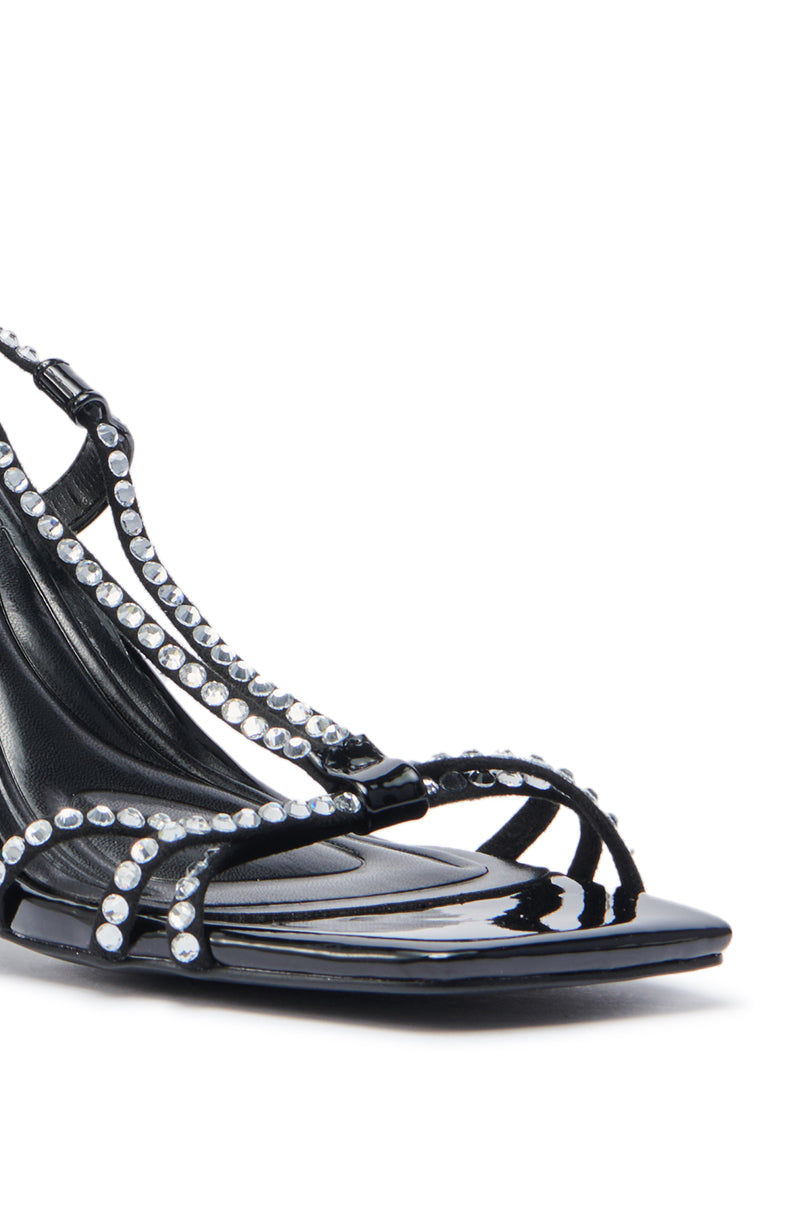 Close-up of the AZALEA WANG GOMER SPARKLE RHINESTONE LACE UP SANDAL—a black faux patent leather high heel with a square toe and rhinestone-embellished straps—photographed against a white background. 6