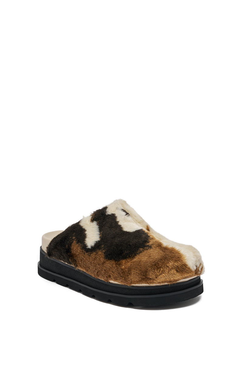 The AZALEA WANG GOVINDA MULTI SLIP ON COW PRINT CLOG features a black sole and a plush brown, black, and white cow print faux fur upper.