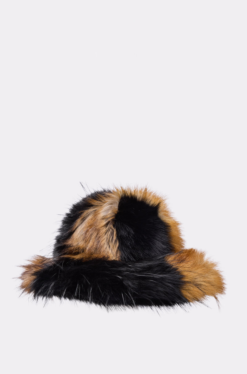 The COSMO FAUX FUR OVERSIZED BUCKET HAT features thick black and brown faux fur patches, offering stylish warmth and comfort—an ideal accessory for cold weather, shown here against a plain light background.