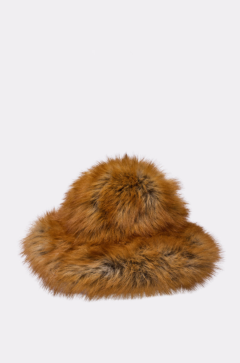 The HOT GIRL FAUX FUR OVERSIZED BUCKET HAT, a fluffy brown bucket hat with wide brim and varied fur tones, is shown against a plain light gray background—a stylish, cozy winter accessory.