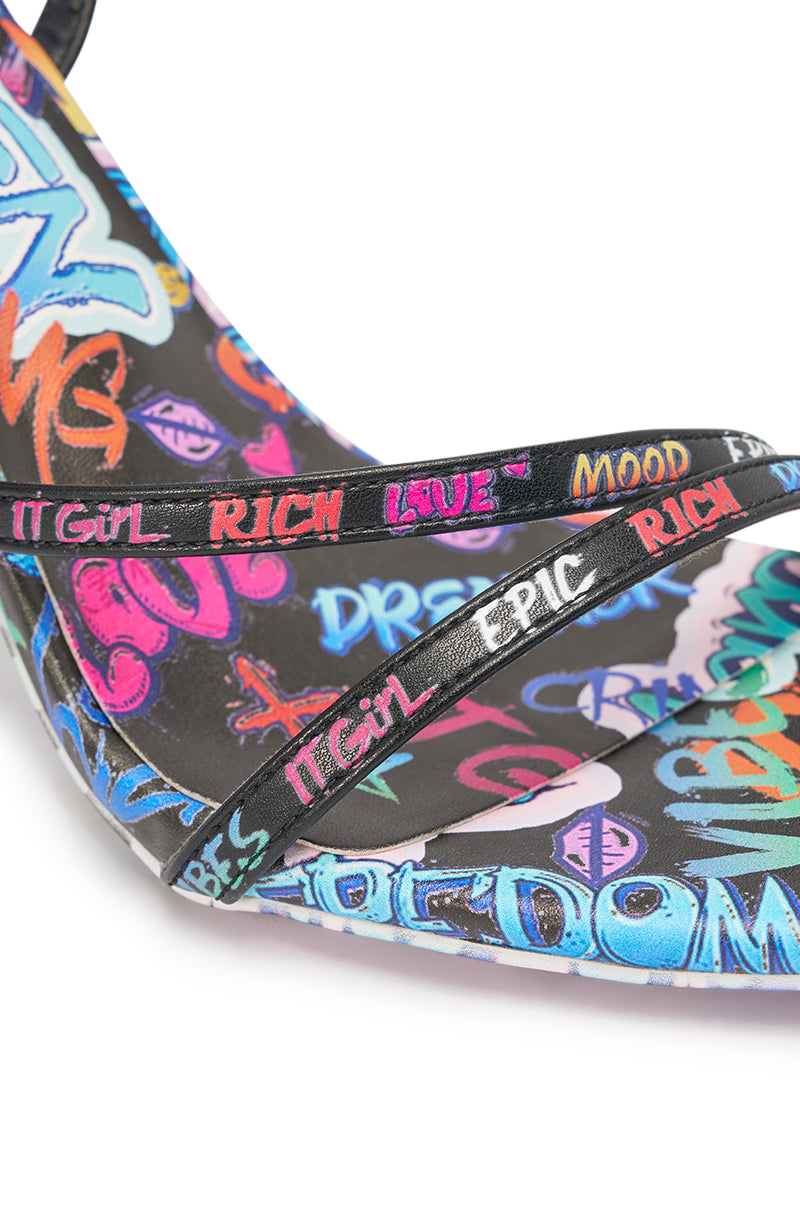 The AKIRA GOLD GRAFFITI PRINT STILETTO SANDAL features a bold, vibrant street art design with graffiti-style text like "IT GIRL," "RICH," and "MOOD" on the straps—an eye-catching choice for party lovers. 6
